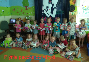 Zdjęcie przedstawia grupę dzieci z prezentami w ręku przeznaczone do wysłania dla dzieci z Afryki.